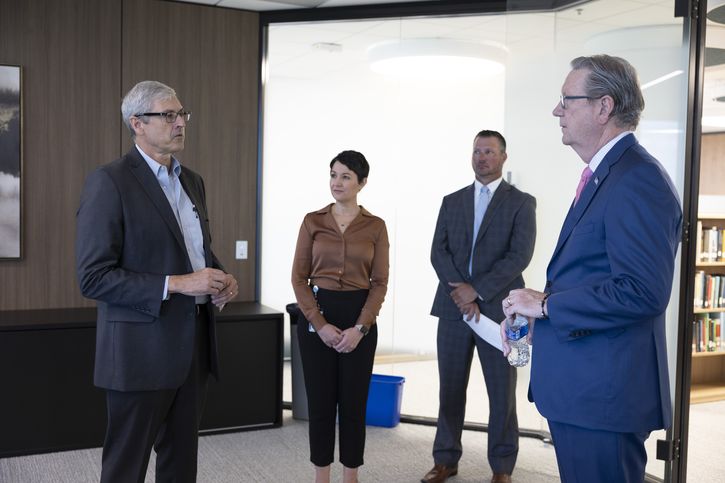 During tours of Bank offices with Facilities Management Assistant Vice President Matt Ruemker (right center), Jeff Schmid stopped in the Economic Research Division to talk with Assistant Vice President Bob Hampton (left) and Vice President Jennifer O'Bryan. Photo by Gary Barber