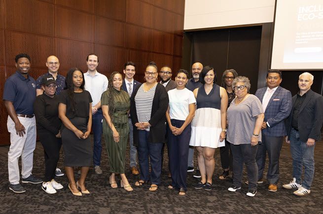 Sixteen people who attended the KC BizCare discussion on building a stronger ecosystem for entrepreneurs of color pose together, smiling.