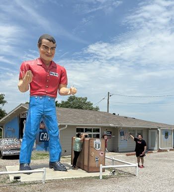 The first thing you see is Big Bill, a 22-foot-tall fiberglass Muffler Man, and his gigantic suitcase. A woman stands nearby. She comes up to Big Bill's knees. Her husband is taking a photo.