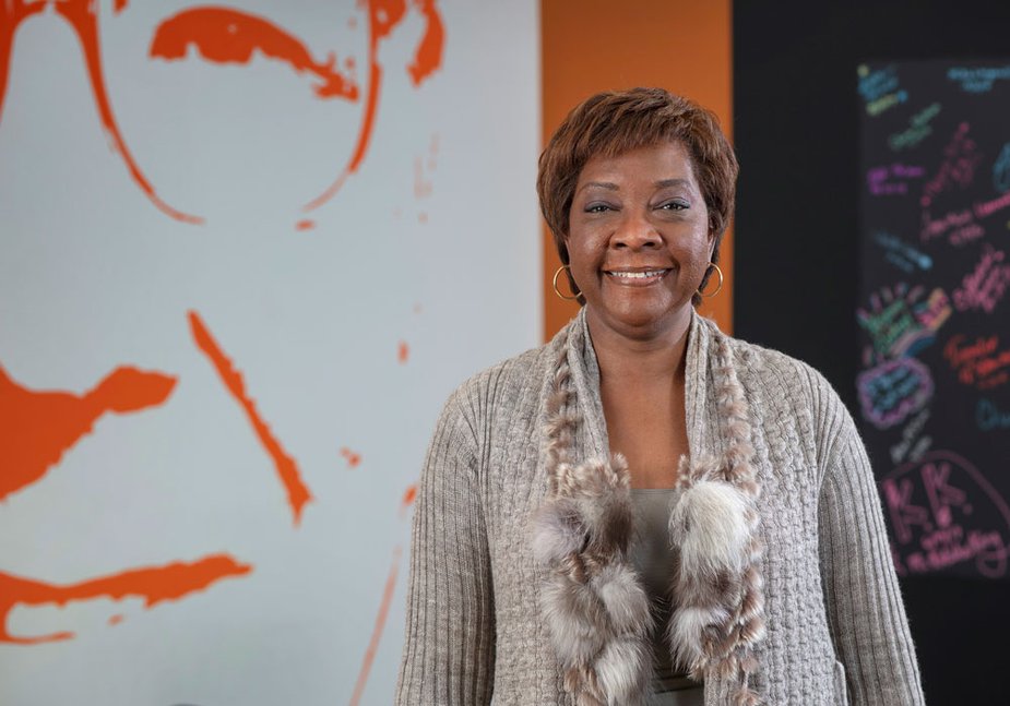 Carmen Tapio of the Kansas City Fed's Omaha Branch Board of Directors standing in front of a piece of art.