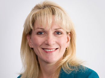 Denise Connor of the Kansas City Fed smiling in a blue suit