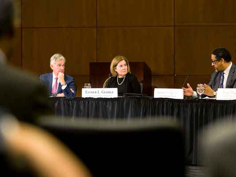 Kansas City Fed President and CEO Esther George sitting at a table next to Jerome Powell, Federal Reserve Chairman.