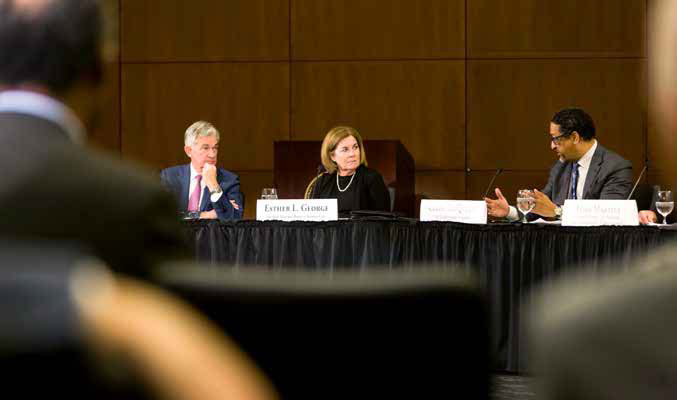 Kansas City Fed President and CEO Esther George sitting at a table next to Jerome Powell, Federal Reserve Chairman.