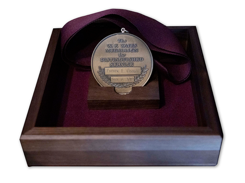 The W.F. Yates Medallion for Distinguished Service sitting in a wooden box lined with velvet.