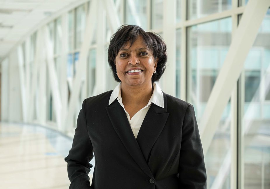 Jandel Allen-Davis of the Kansas City Fed's Denver Branch Board of Directors standing near windows in a suit.