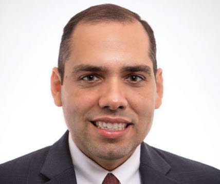 Josias Aleman of the Kansas City Fed smiling in a dark suit