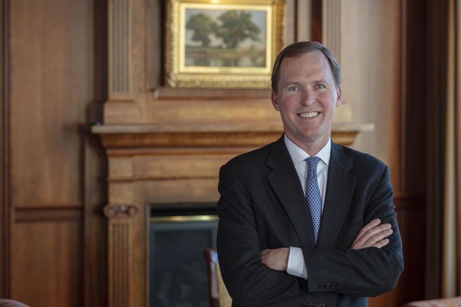 Clark Lauritzen of the Kansas City Fed's Omaha Branch Board of Directors standing in front of a fire place..