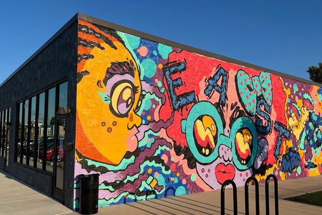 Another fabulous mural in northeast Oklahoma City. It's on a long, one-story building. It looks like a party on a cartoon playground, with little kids, sunglasses, what look like waves and lots of bright colors.