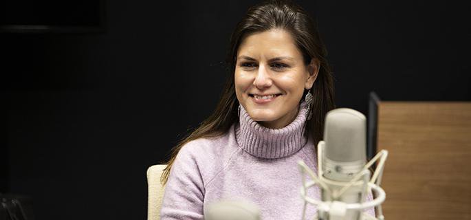 Kansas City Fed Senior Economist Didem Tüzemen sitting in front of a microphone.