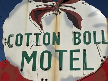 The old Cotton Boll Motel neon sign in Canute, Oklahoma, is worn and ragged.