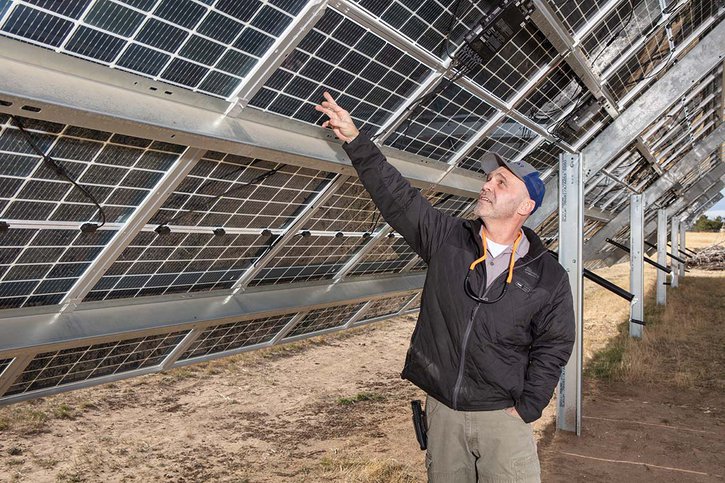 Ray Woods, operations manager at The Solar Guys, pointing at solar panels the company installed in Wyoming.